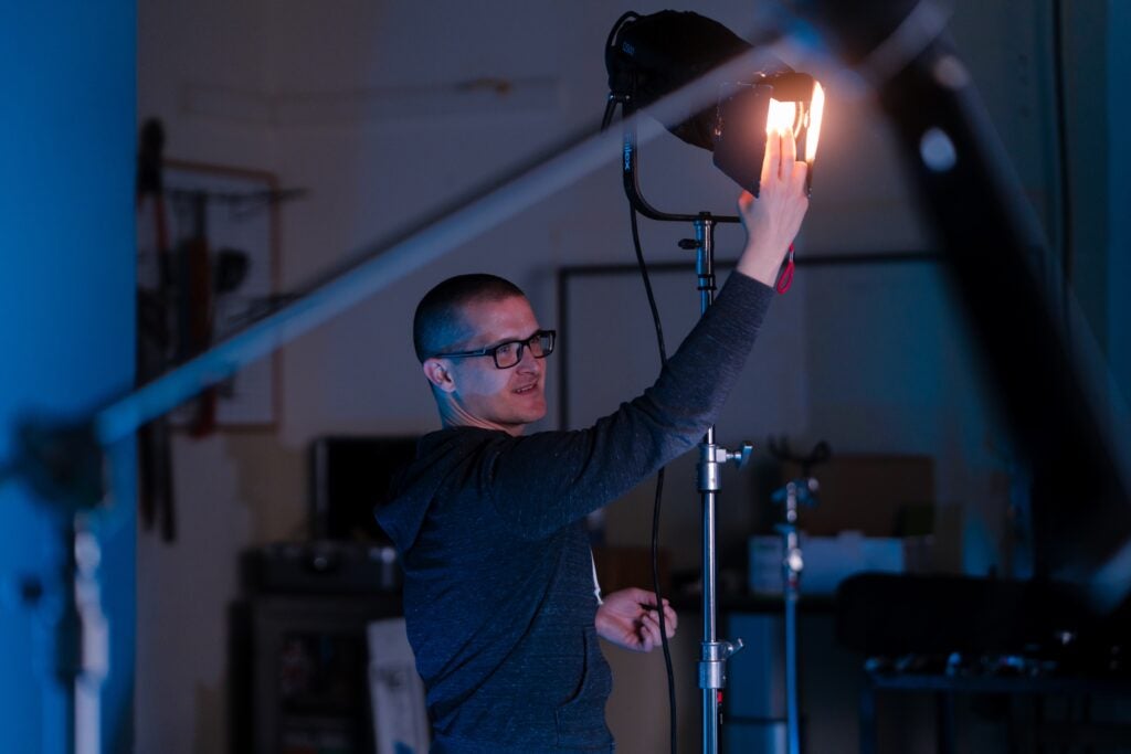 Photo of videographer adjusting lighting in studio